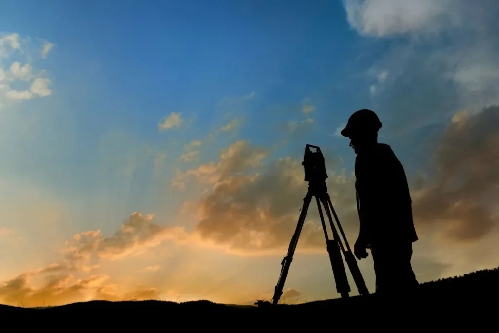 Ingénieur Envealia effectuant un relevé topographique sur le terrain